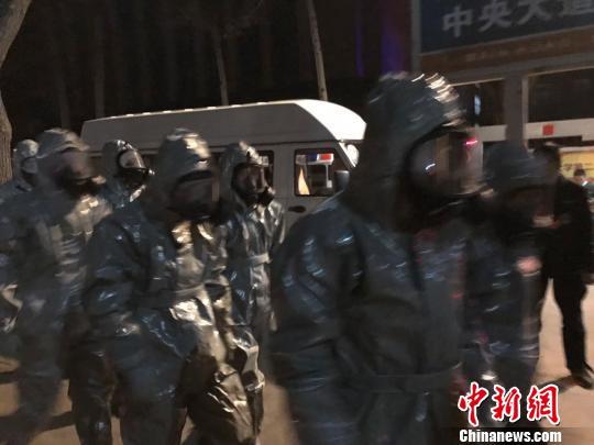 十几名身着防护服的人员头戴面具进入事发地。　胡健 摄